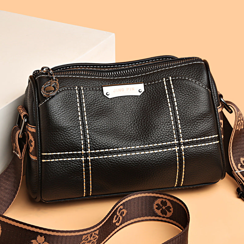Borsa a tracolla in pelle nera con cuciture bianche, design elegante, cinturino regolabile marrone, ideale per moda donna, accessori di tendenza.