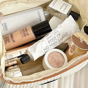 Beauty case con prodotti cosmetici: fondotinta, lozione, profumo, crema viso, rossetto. Ideale per trucco quotidiano e cura della pelle.