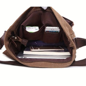 Interno di una borsa a tracolla marrone con tasche multiple, contenente smartphone, tablet e quaderni. Design pratico per organizzazione quotidiana.