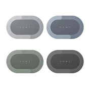 Quattro tappetini ovali antiscivolo in diverse tonalità di grigio e verde, con scritta "HOME" al centro. Ideali per ingresso o cucina.