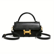 Borsa a tracolla nera in pelle con chiusura dorata a forma di H, manico superiore e tracolla regolabile. Elegante accessorio moda donna.
