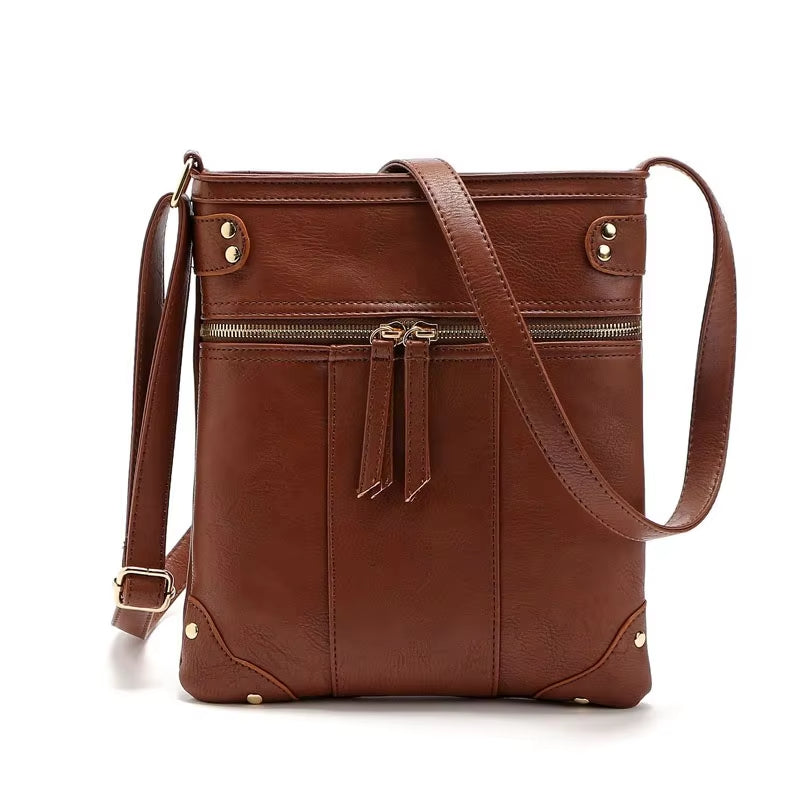 Borsa a tracolla in pelle marrone con cerniera, design elegante e moderno, ideale per donna. Accessorio moda versatile e di tendenza.