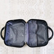 Borsa da viaggio aperta su tappeto bianco, con scomparti a rete e design esagonale. Ideale per organizzare accessori e cosmetici.