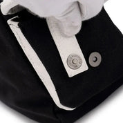 Borsa nera in tessuto con dettagli bianchi, chiusura a bottone in metallo argentato, design elegante e moderno. Accessorio moda di alta qualità.