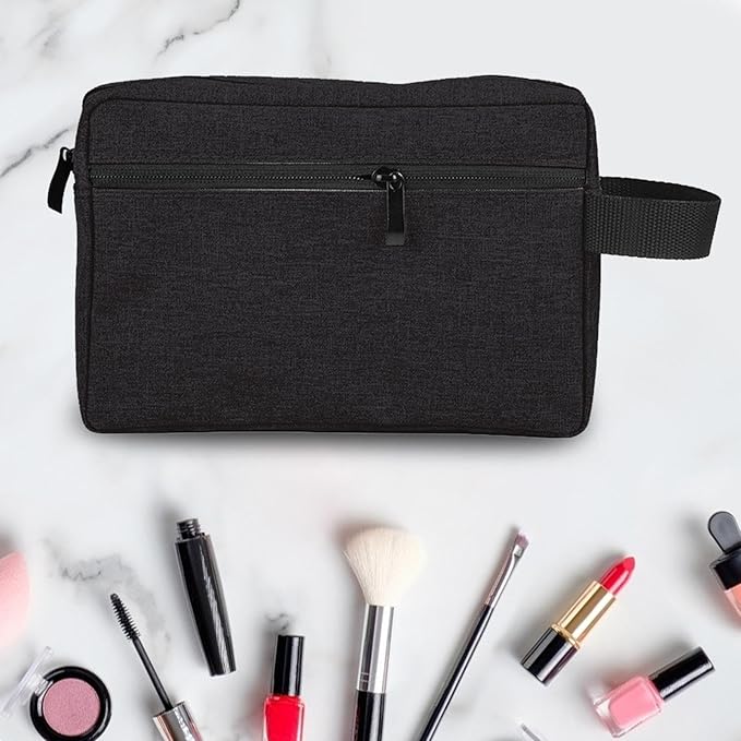Borsa da toilette nera su sfondo bianco con accessori trucco: rossetti, pennelli, smalti. Ideale per organizzare cosmetici e prodotti di bellezza.