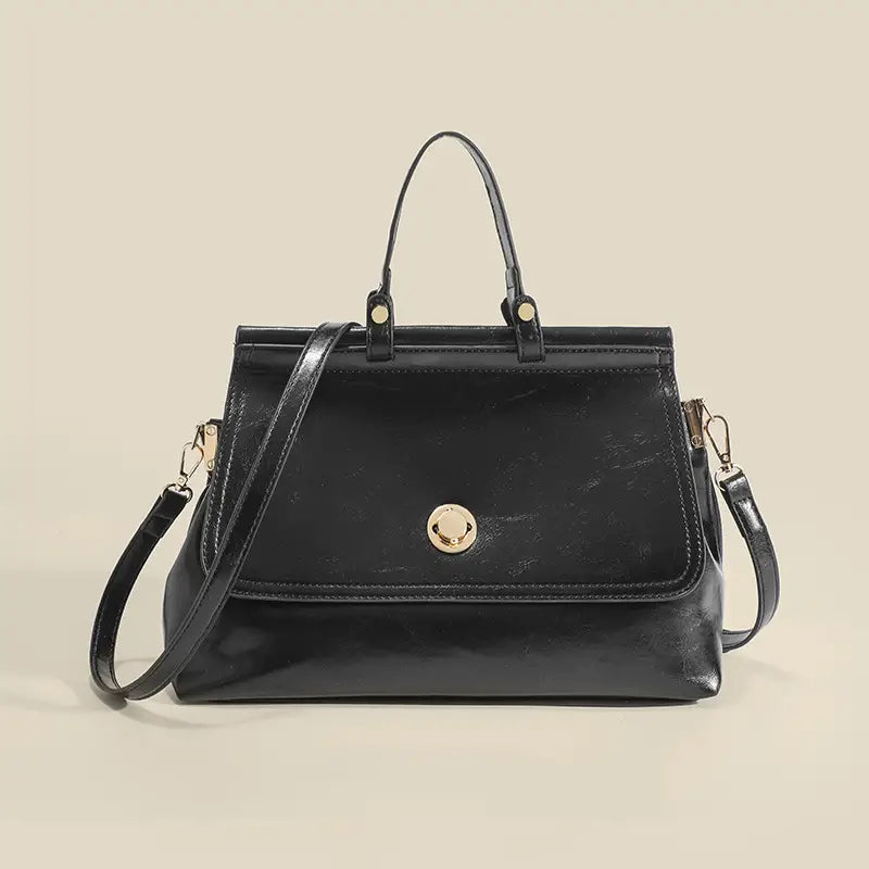 Borsa a mano in pelle nera con tracolla, design elegante, chiusura dorata, ideale per moda donna, accessorio versatile e chic.