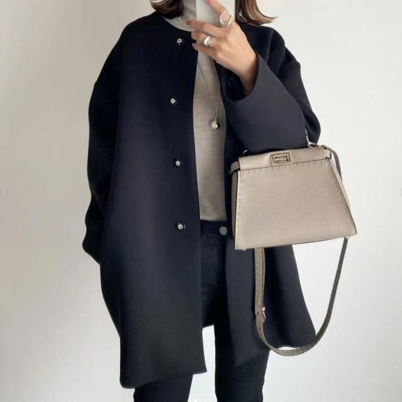 Cappotto nero elegante donna, abbinato a borsa a tracolla beige, moda autunno inverno, stile casual chic, outfit femminile moderno.