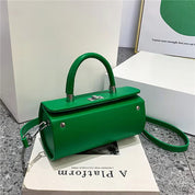 Borsa a mano verde elegante con tracolla, design moderno, chiusura a scatto, su sfondo minimalista. Accessorio moda donna, stile contemporaneo.