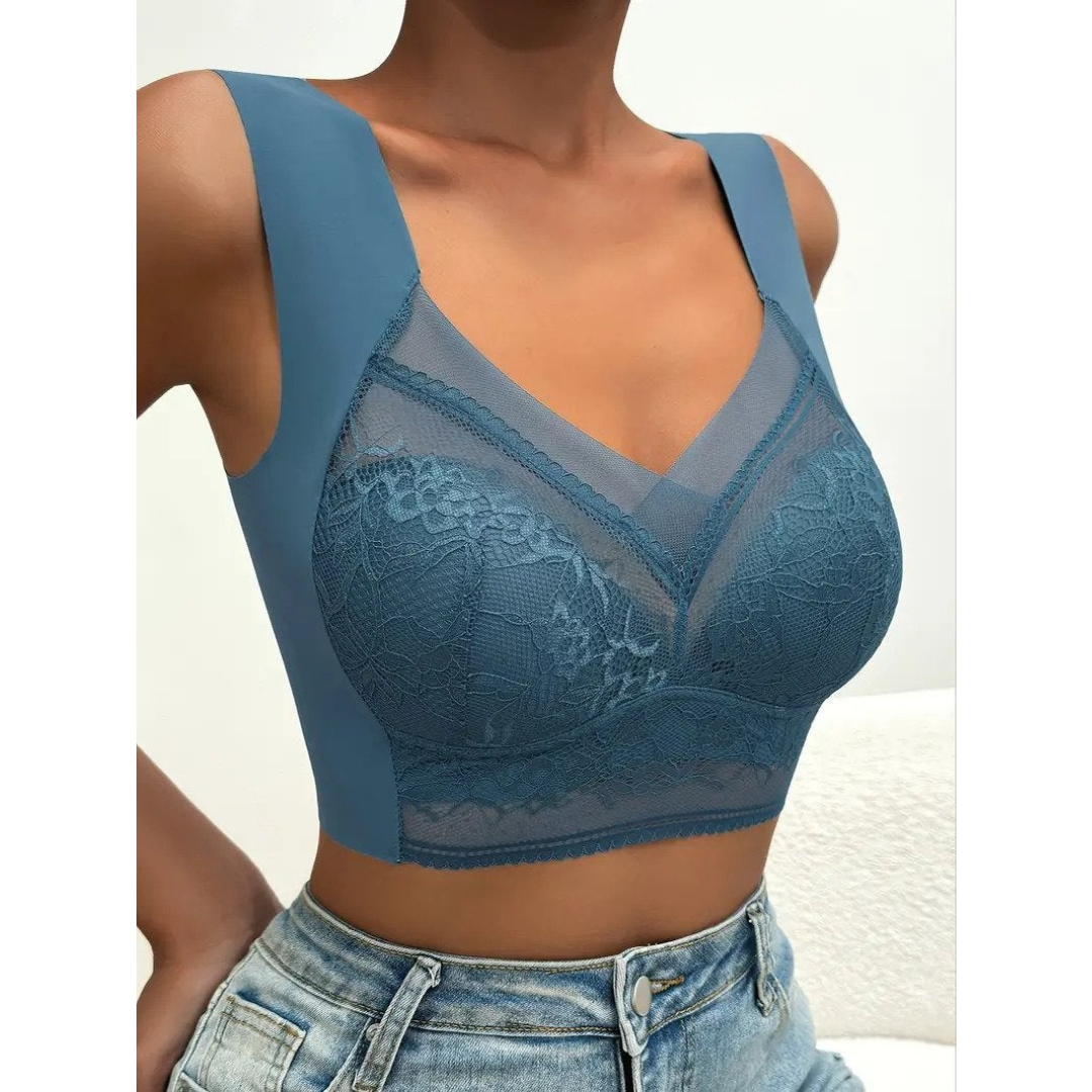 Top in pizzo blu, senza maniche, con scollo a V e dettagli trasparenti, indossato con jeans. Elegante e moderno, perfetto per moda casual.