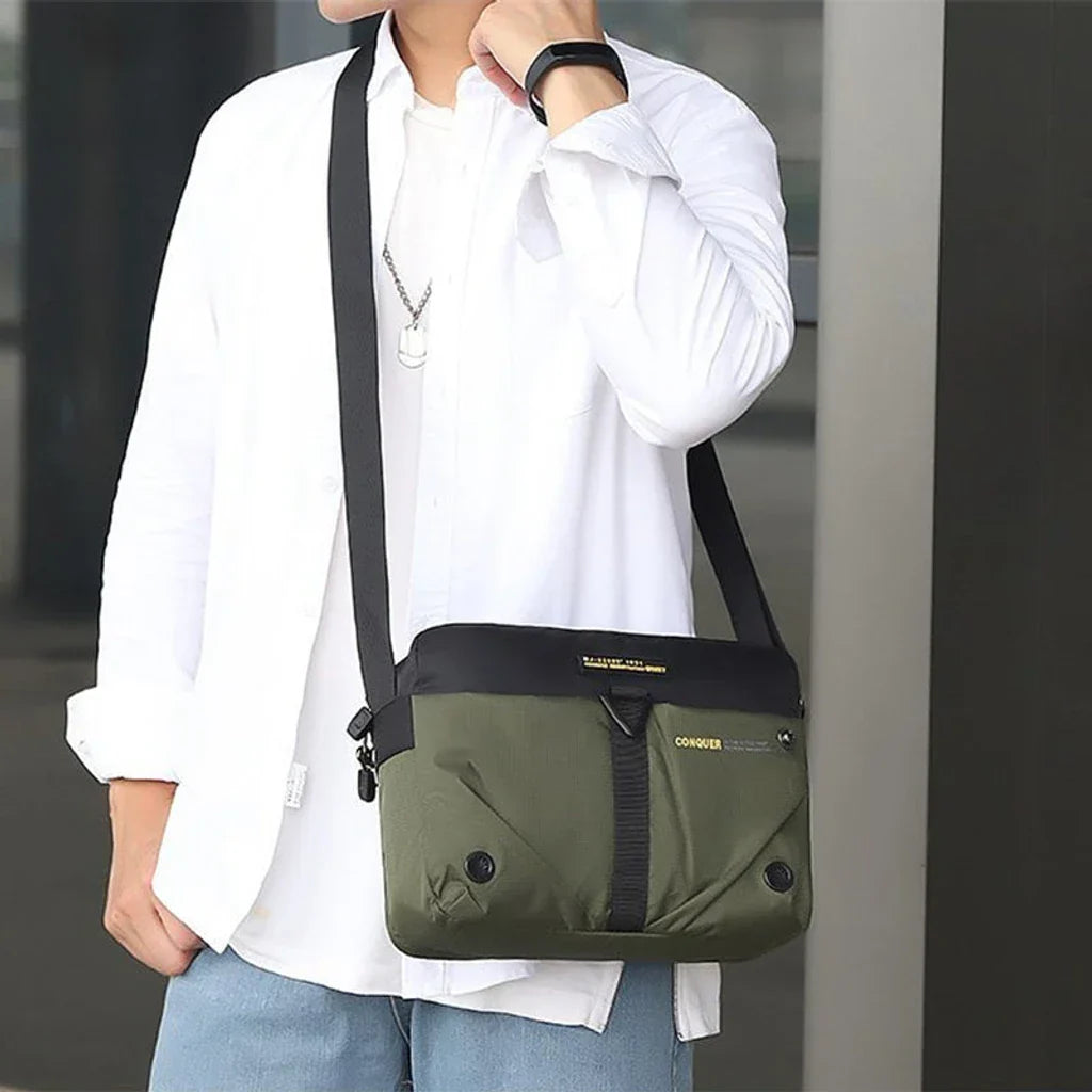 Borsa a tracolla verde e nera indossata da una persona con camicia bianca. Design moderno, ideale per uomo, casual e versatile.
