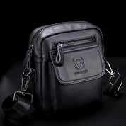 Borsa a tracolla in pelle nera da uomo, con cerniere multiple e logo inciso, ideale per viaggi e uso quotidiano. Design compatto ed elegante.