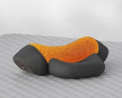 Cuscino ergonomico arancione e nero su superficie grigia, design a nido d'ape, supporto cervicale, ideale per comfort e postura corretta.