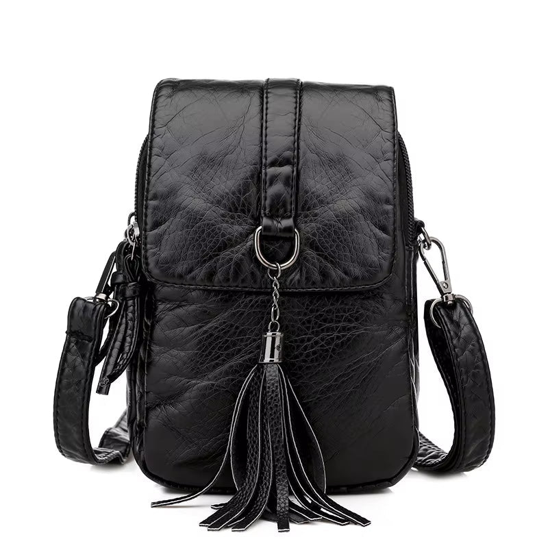 Zaino in pelle nera con nappina decorativa, chiusura a zip, tracolla regolabile. Elegante e pratico per uso quotidiano o viaggio.
