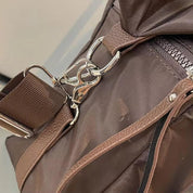 Borsa a tracolla marrone in tessuto resistente con cerniera e moschettone in metallo argentato, ideale per viaggi e uso quotidiano.