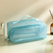 Borsa da toilette trasparente azzurra con cerniera, manico superiore, ideale per viaggi, organizzazione cosmetici, bagno. Design elegante e pratico.