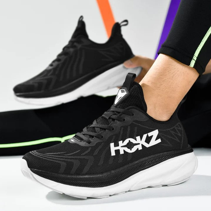 Scarpe da corsa nere HOKZ con suola bianca, design moderno e logo in evidenza. Ideali per sportivi, comfort e prestazioni elevate.