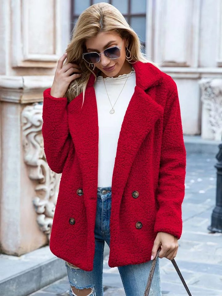 Donna con cappotto rosso in lana, occhiali da sole, jeans strappati e maglia bianca. Moda autunnale, abbigliamento casual elegante.