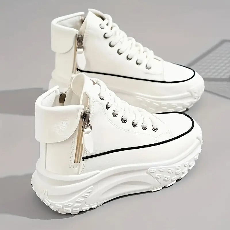Scarpe da ginnastica alte bianche con suola spessa, dettagli in metallo e zip laterale, su sfondo grigio. Sneakers moda, calzature casual.