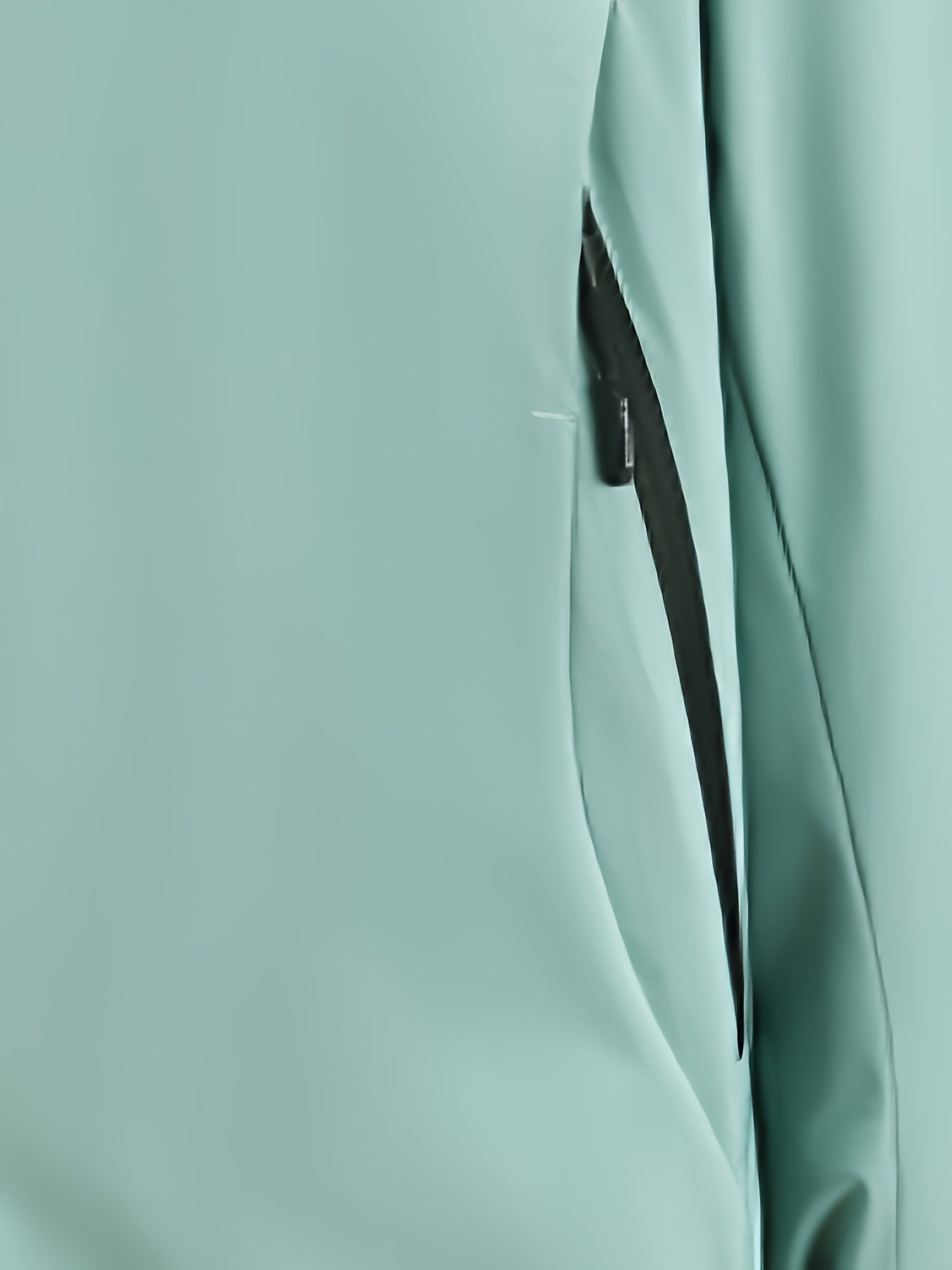 Giacca impermeabile verde menta con cerniera nera, tessuto tecnico resistente, ideale per attività outdoor e sport all'aperto.