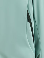 Giacca impermeabile verde menta con cerniera nera, tessuto tecnico resistente, ideale per attività outdoor e sport all'aperto.