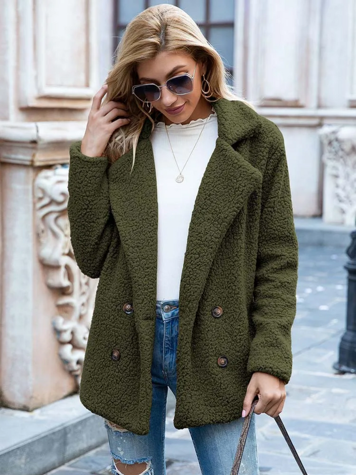 Donna con cappotto verde oliva in pile, occhiali da sole, maglia bianca e jeans strappati. Moda autunnale, stile casual chic.