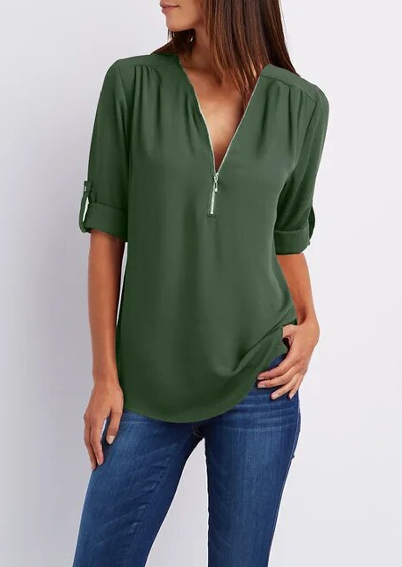 Blusa verde donna con zip, maniche a 3/4 arrotolate, scollo a V, abbinata a jeans. Moda casual elegante, tessuto leggero, stile versatile.