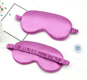 Due mascherine per dormire in seta viola su sfondo bianco, ideali per il relax e il sonno. Accessori per il benessere e il riposo notturno.