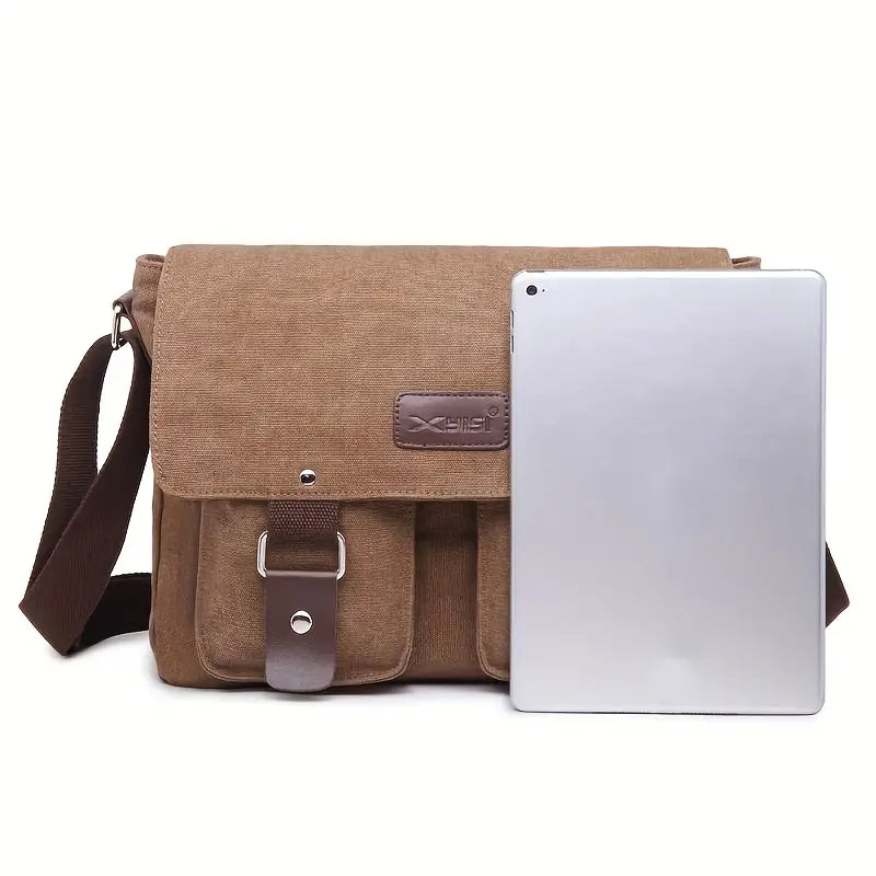 Borsa a tracolla in tela marrone con patta, tasche frontali e cinturino regolabile, accanto a tablet argento. Ideale per lavoro e viaggio.