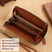 Portafoglio in pelle marrone con cerniera, scomparti multipli per carte, contanti e monete. Design elegante e funzionale, ideale per uomo e donna.