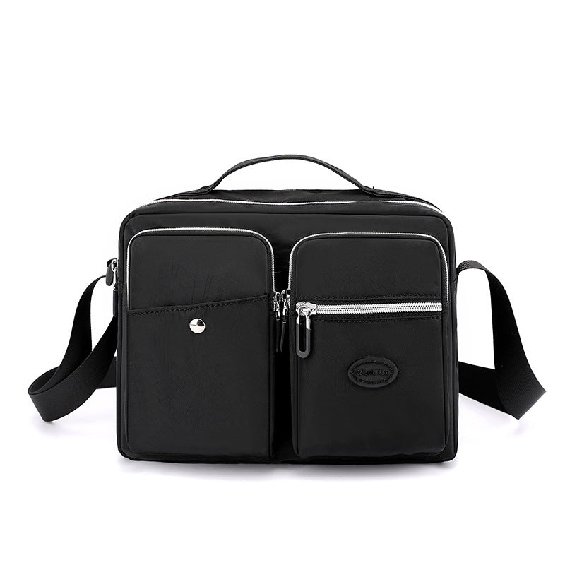 Borsa a tracolla nera unisex, design moderno, con tasche multiple e cerniere, ideale per lavoro e viaggio. Materiale resistente e impermeabile.