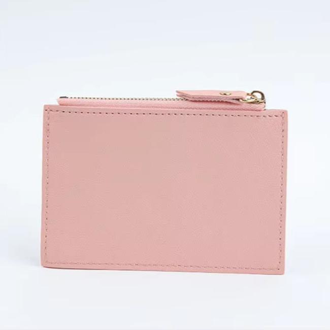 Portafoglio donna in pelle rosa chiaro con cerniera dorata, design minimalista, accessorio moda elegante, ideale per carte e contanti.