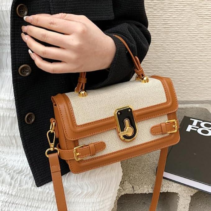 Borsa a tracolla elegante in pelle marrone e tessuto beige, chiusura con fibbia dorata, indossata da una persona. Accessorio moda donna.