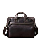 Borsa ventiquattrore in pelle marrone scuro con manici e tracolla regolabile, tasche frontali con zip, design elegante e professionale.