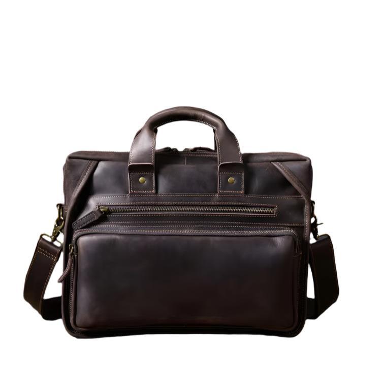 Borsa ventiquattrore in pelle marrone scuro con manici e tracolla regolabile, tasche frontali con zip, design elegante e professionale.
