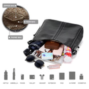 Borsa a tracolla nera in pelle con borchie, aperta per mostrare contenuto: ombrello, telefono, portafoglio, occhiali da sole, cosmetici, iPad, quaderno.