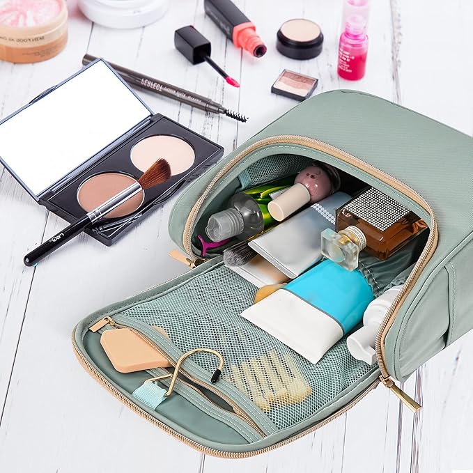 Beauty case verde aperto su tavolo bianco, contenente cosmetici, pennelli trucco, specchio e prodotti skincare. Organizzatore da viaggio elegante e pratico.