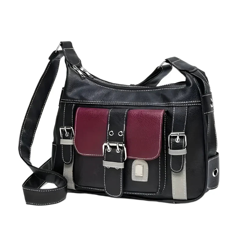Borsa a tracolla in pelle nera con tasca frontale bordeaux e dettagli grigi. Design elegante, ideale per moda donna e accessori di tendenza.
