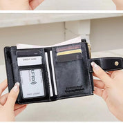 Portafoglio in pelle nero con protezione RFID, scomparti per carte di credito, tasca per monete e chiusura a bottone. Design elegante e funzionale.