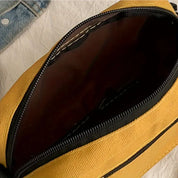 Borsa a tracolla gialla aperta, tessuto resistente, cerniera nera, interno spazioso. Accessorio moda casual, ideale per uso quotidiano.