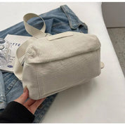 Borsa a tracolla in tessuto bianco a coste su giacca di jeans, design casual e moderno, perfetta per moda urbana e stile quotidiano.