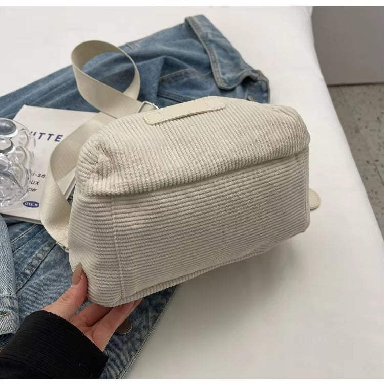 Borsa a tracolla in tessuto bianco a coste su giacca di jeans, design casual e moderno, perfetta per moda urbana e stile quotidiano.
