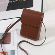 Borsa a tracolla in pelle marrone, design minimalista, chiusura a patta, ideale per moda donna, accessorio elegante e versatile.