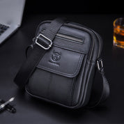 Borsa a tracolla in pelle nera da uomo con tasca frontale e cerniera, design elegante e moderno, ideale per lavoro e viaggi. Accessorio moda maschile.