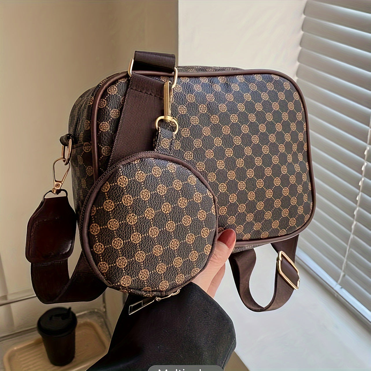 Borsa a tracolla marrone con motivo geometrico, accessorio rotondo abbinato, dettagli in metallo dorato, perfetta per moda donna e accessori eleganti.