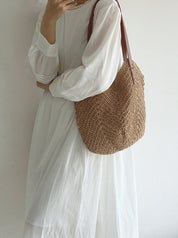 Donna con abito bianco lungo e borsa a tracolla in paglia intrecciata. Moda estiva, accessori eleganti, stile casual chic.