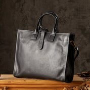 Elegante borsa in pelle nera con manici, design classico, su sfondo scuro. Accessorio moda di lusso per uomo o donna.