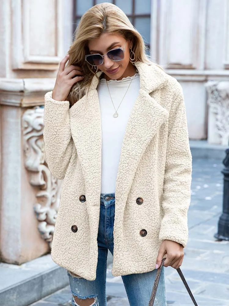 Donna con cappotto in pile beige, occhiali da sole, jeans strappati e maglia bianca. Moda autunnale, abbigliamento casual elegante.