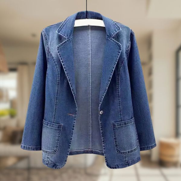 Giacca blazer in denim blu, stile casual, con tasche frontali, appesa su gruccia. Perfetta per look moda donna autunno-inverno.