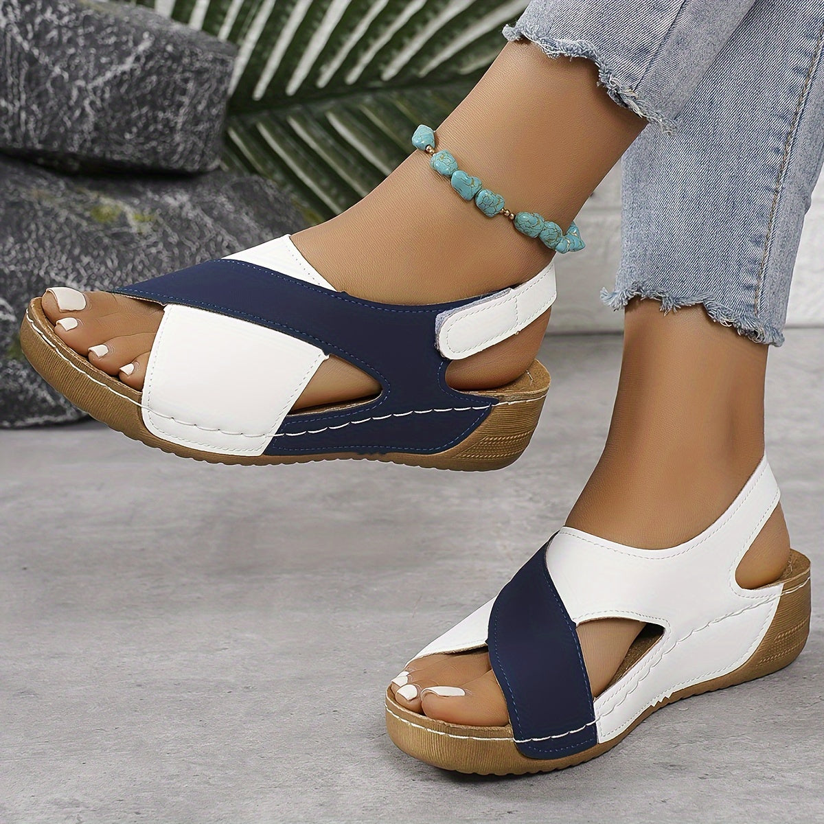 Sandali donna estivi con zeppa, design bicolore blu e bianco, cinturino regolabile, suola in legno, abbinati a jeans e cavigliera turchese.