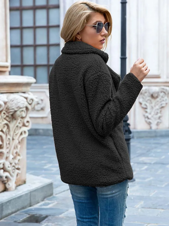 Giacca in pile nero donna, stile casual, indossata all'aperto. Moda autunno inverno, tessuto caldo e morbido, ideale per look urbano.